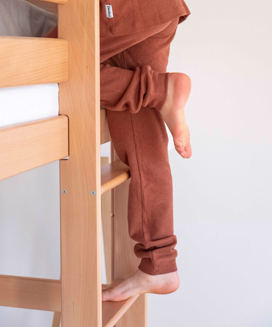 Trittsicher!*Dank unserer trittsicheren Leiter ist ein leichter und sicherer Einstieg für dein Kind garantiert.|Detailansicht der Leiter, auf der gerade ein Kind hoch steigt.