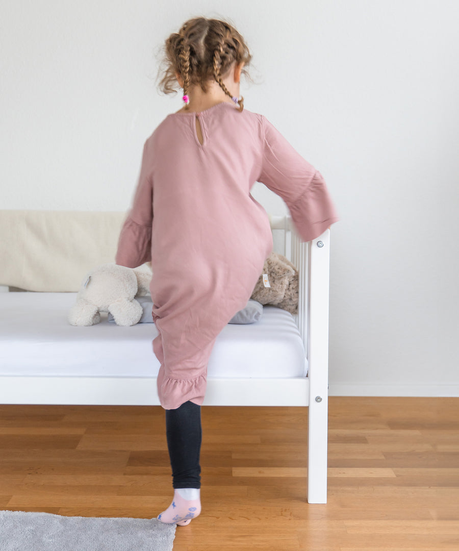 Leichter Einstieg*Durch die kinderfreundliche Bauweise unseres Kinderbetts ist der Einstieg kinderleicht.|Mädchen steigt auf Kinderbett Buche weiß. 