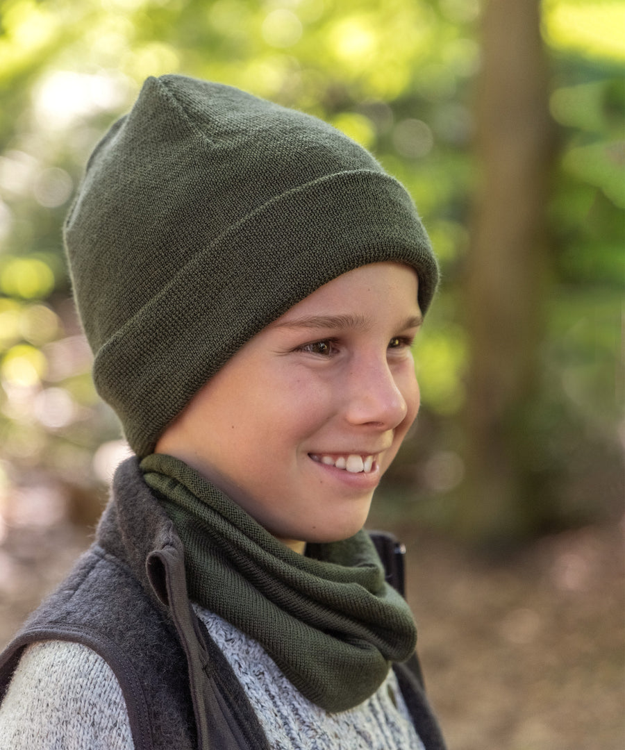 Junge mit Strickmütze und Schlauchschal in Oliv.
