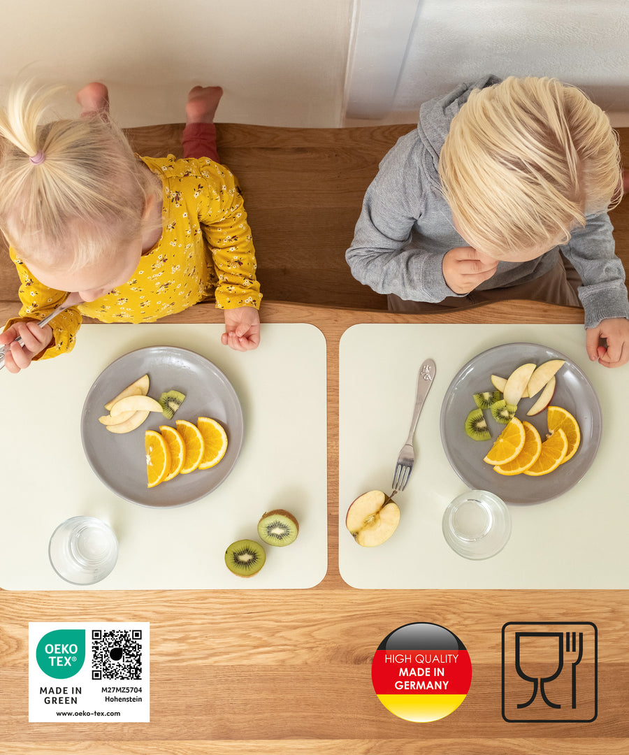 Stilvoller Schutz*Schlichtes Design in acht wunderschönen Farben - da ist für jeden Geschmack und Einrichtungsstil die passende Variante dabei. Tischset in Salbeiweiß.|Zwei Kinder essen Obst auf Tischsets, die Schutz und stilvolle Optik bieten.