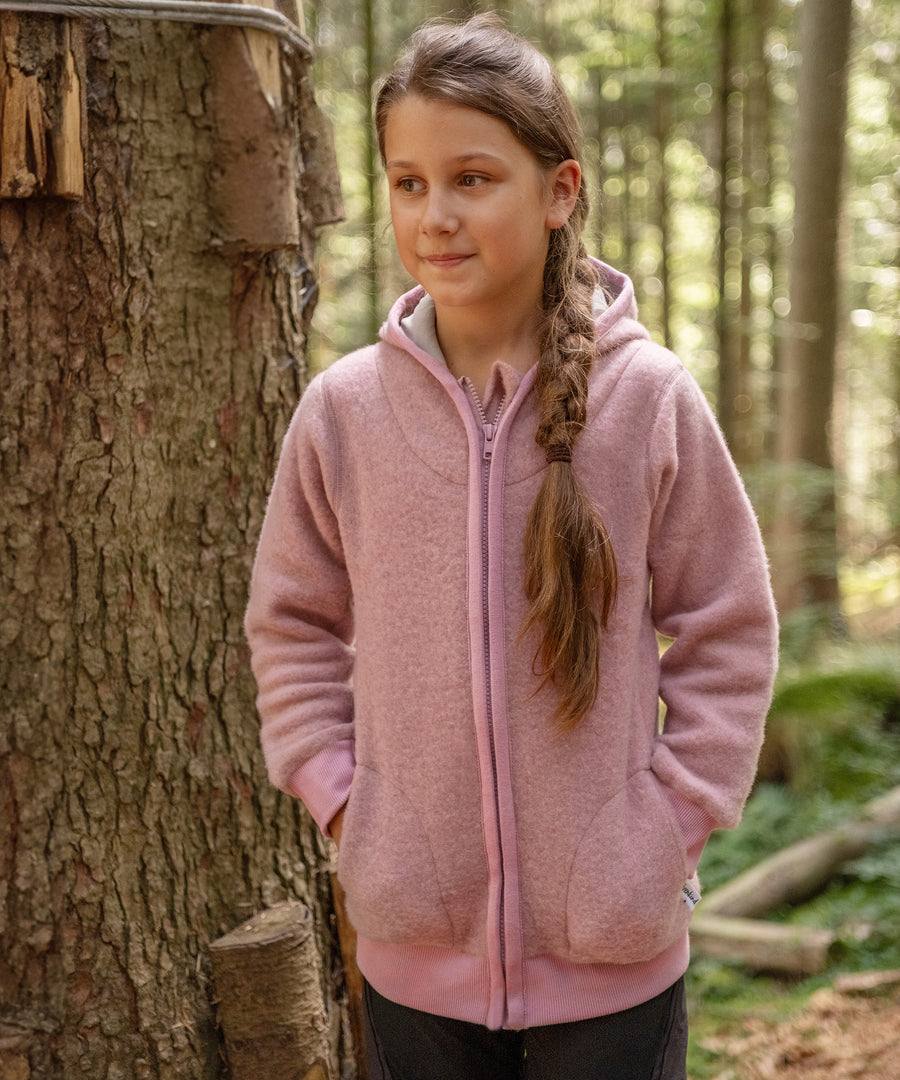Angenehmes Tragegefühl*Der Jacke ist leicht und anschmiegsam, da drückt und stört nichts. Das isolierende Fleece schützt zuverlässig gegen Kälte.|Mädchen mit Fleecejacke Altrosa im Wald.