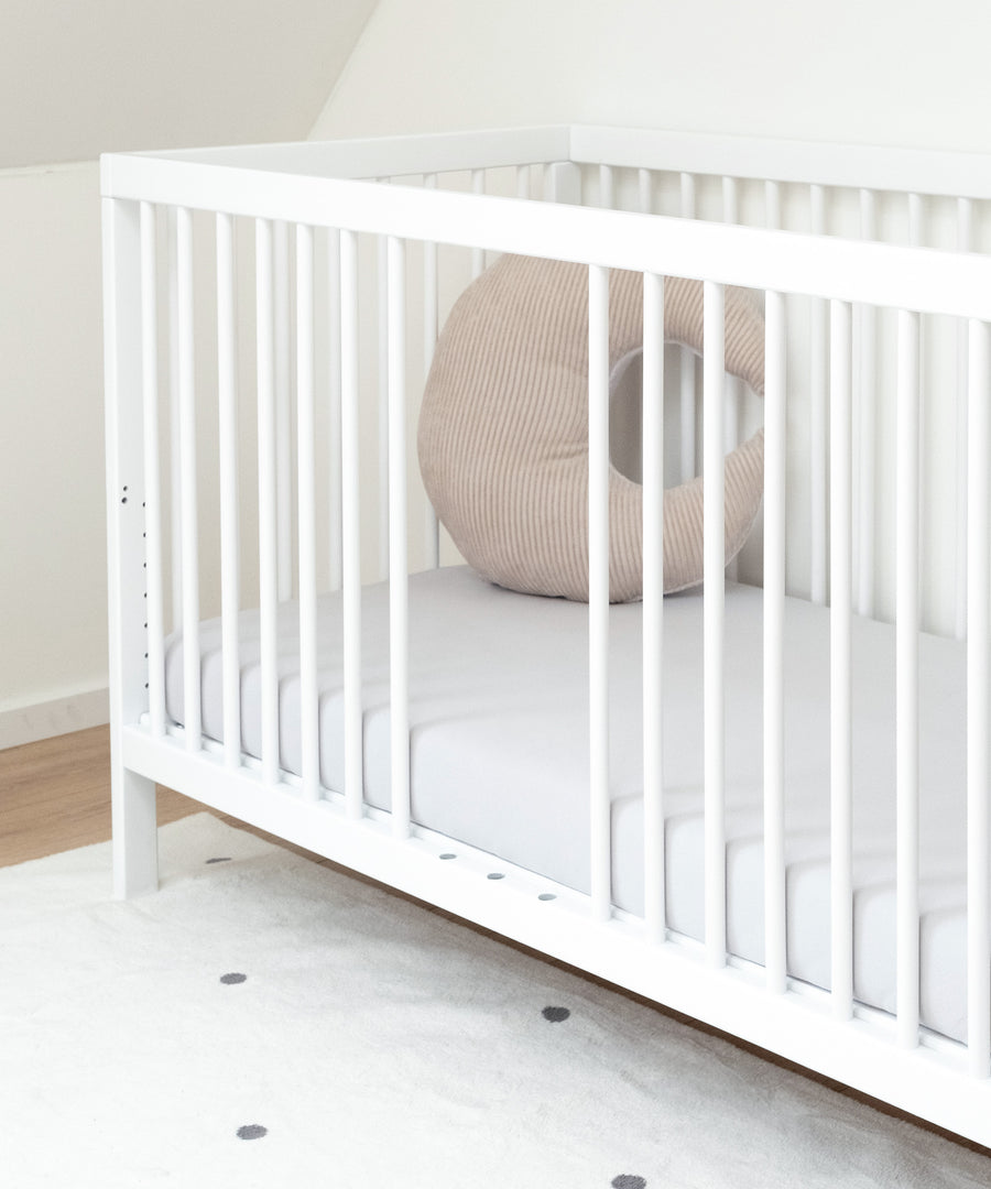 Baby Gitterbett weiß mit herausgenommenen Stäben.