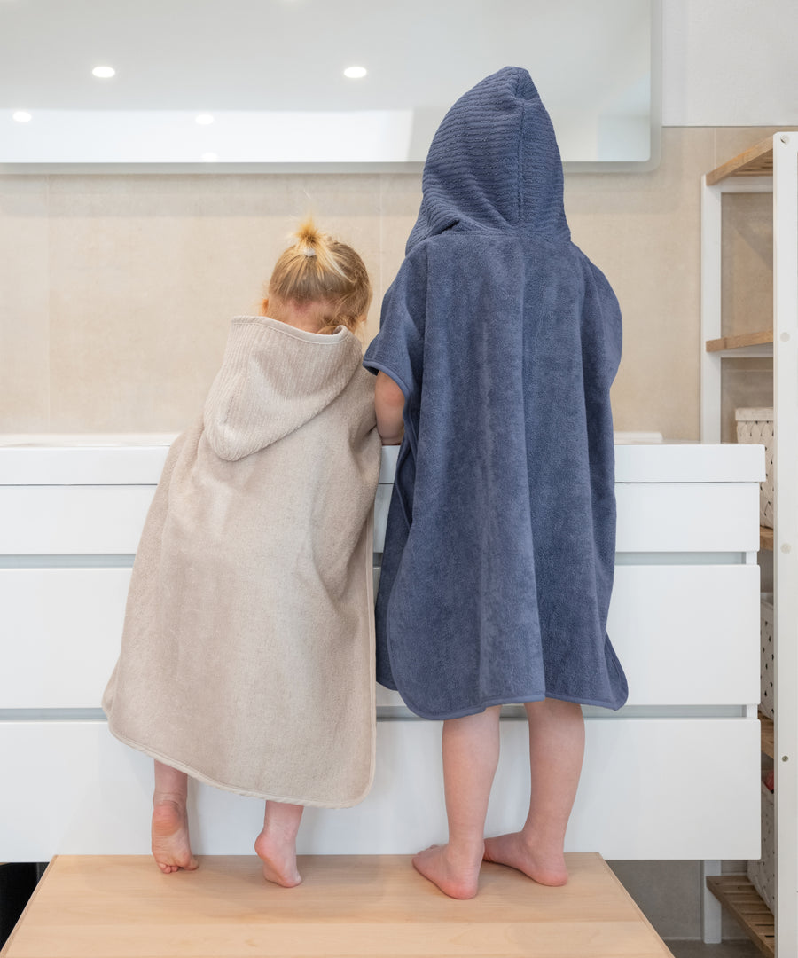 Eine Größe für alle*Der Badeponcho in Einheitsgröße eignet sich optimal für Kinder von ca. 1 bis 5 Jahren.| Zwei unterschiedliche große Kinder stehen nebeneinander im Badeponcho.