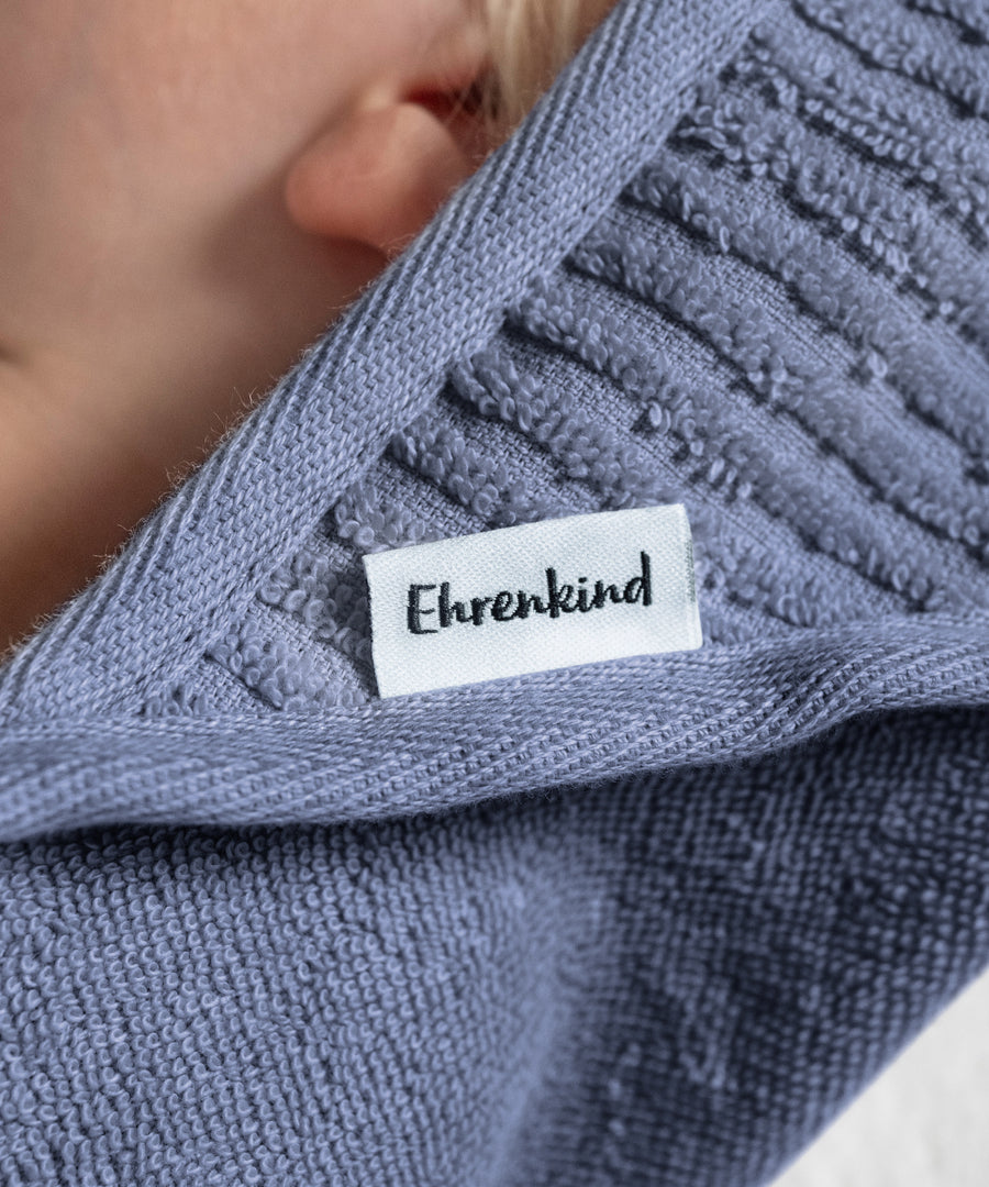 Detailaufnahme des eingenähten Labels am Kapuzenhandtuch.