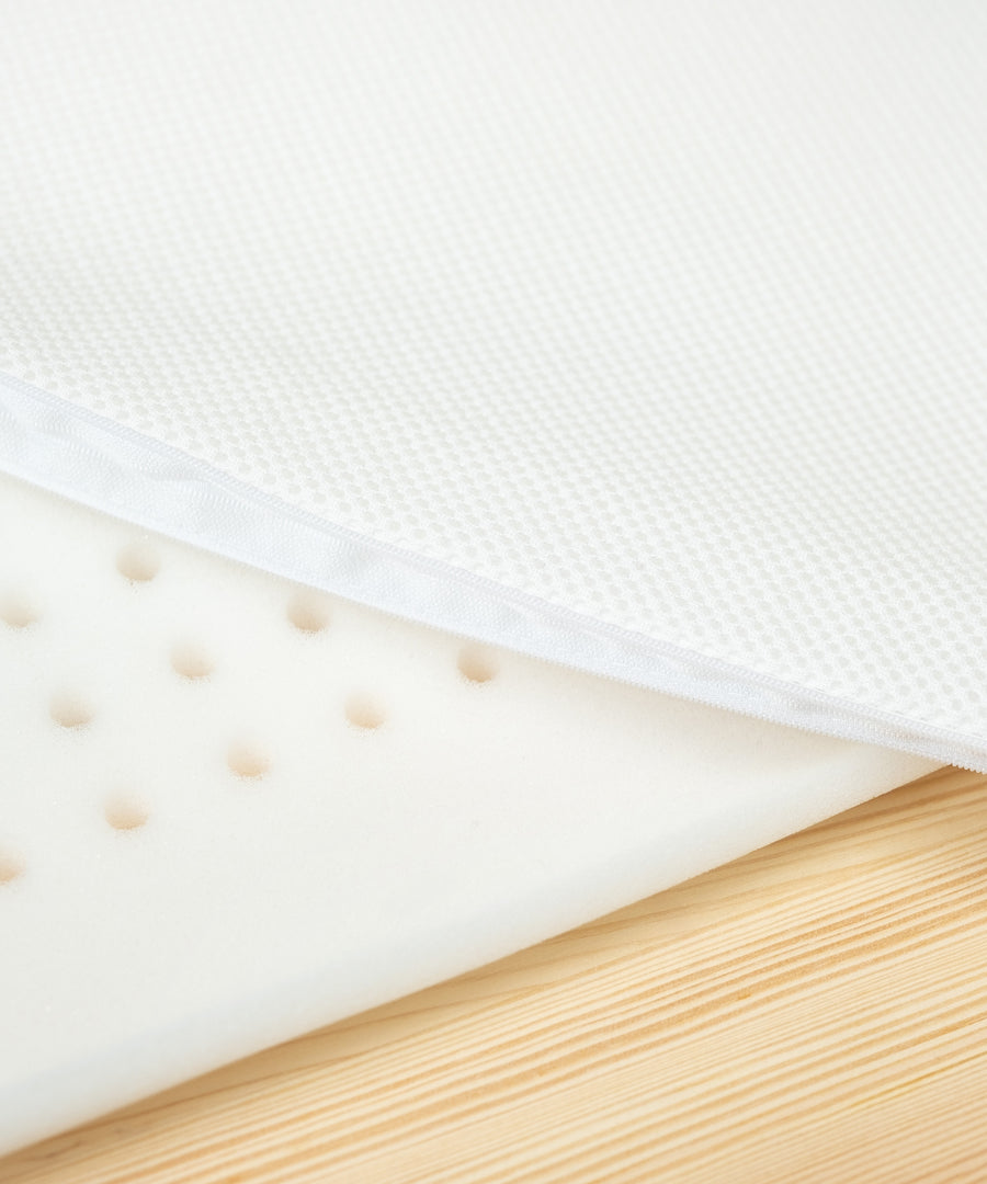 Pflegeleicht & praktisch*Der Meshbezug aus 100% Polyester lässt sich einfach abnehmen und bei 30°C waschen - bestens geeignet für den Alltag mit Baby.|Nahaufnahme Schaumstoff mit Löchern für Belüftung und Mesh-Bezug.
