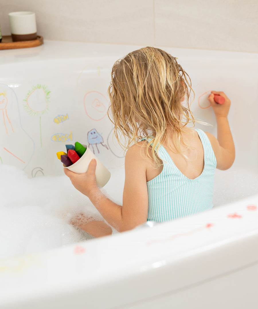 Baden wird zur Kreativzeit*Sieben kräftige Farben machen aus der Baderoutine einen kreativen Spielmoment voller Fantasie.|Kind malt beim Baden mit Badewannenstiften.