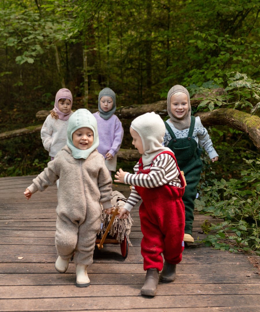 Spielspaß im Freien*Schal und Mütze in einem: Die praktische Schlupfmütze hält Kopf, Hals und Ohren beim Spielen & Erkunden angenehm warm.|Kinder spielen draußen und tragen die Mützen.