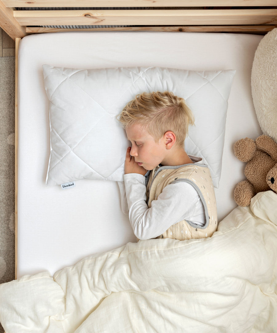 Kuschelig-weich gebettet*Die langlebige, bauschige Füllung aus Polyesterhohlfaser und der Bezug aus 100% Baumwolle schenken Komfort und Geborgenheit.|Kind schläft auf dem Kinderkissen in der Größe 60×40 cm.
