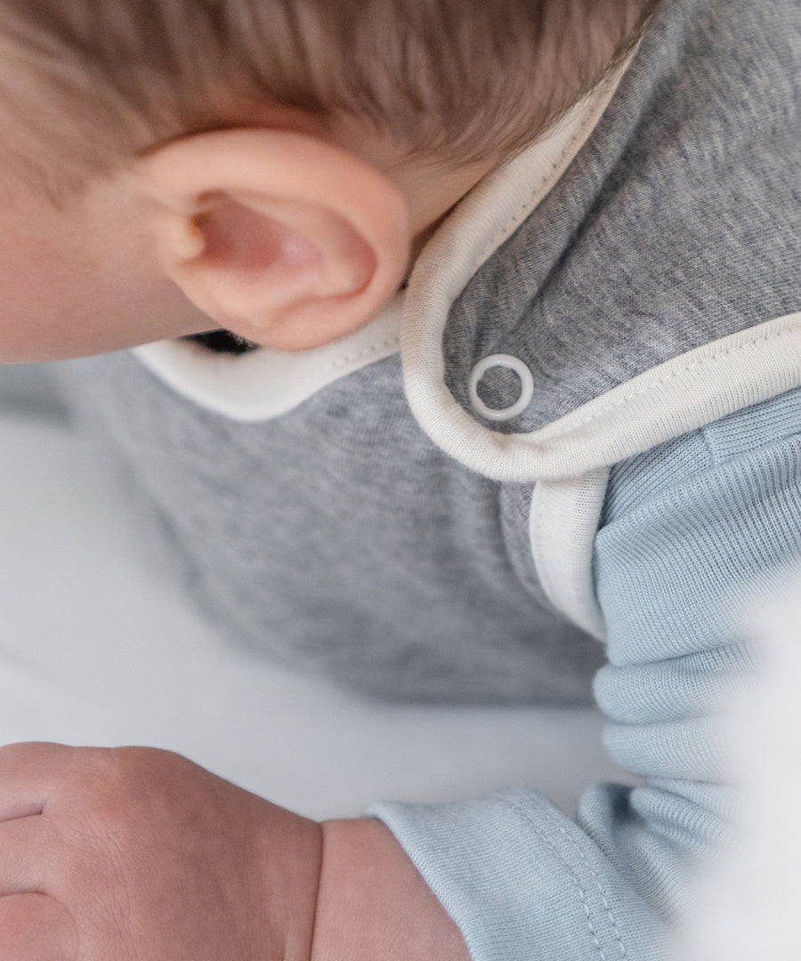 Praktische Druckknöpfe*Der Rund-um-Reißverschluss an der Seite und Druckknöpfe ermöglichen einfaches An- und Ausziehen — für schnelles Wickeln.| Nahaufnahme der Druckknöpfe