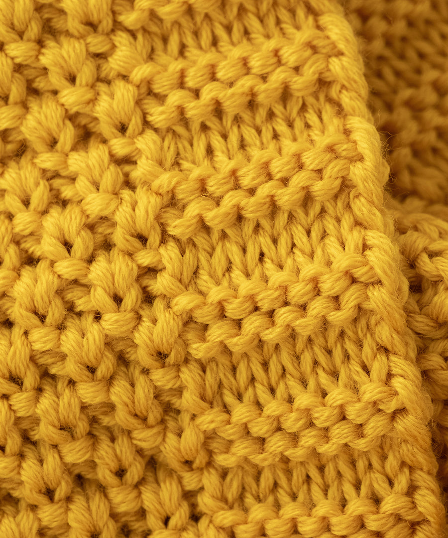 Made in Germany*Hochwertig gefertigt aus Merino Schurwolle und nachhaltig aus kontrolliert biologischer Tierhaltung in Deutschland produziert.| Nahaufnahme von dem Schlauchschal Grobstrick Safran.